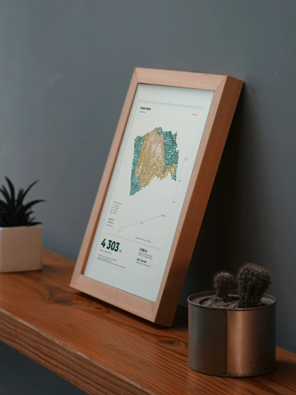 Œuvre Pikes Peak intégrée numériquement dans un cadre, sur une tablette auprès de plantes. Encadrement et proportions indicatifs.