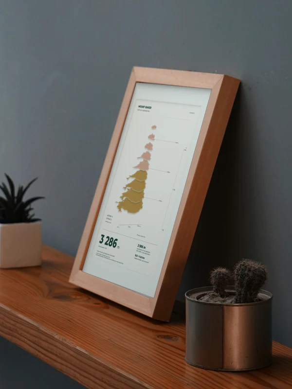 La obra Monte Baker integrada digitalmente en un marco, sobre una repisa junto a plantas. El marco y las proporciones son ilustrativos.