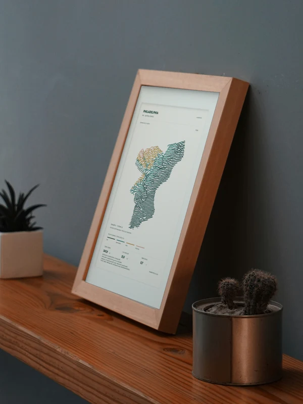 Œuvre Philadelphia intégrée numériquement dans un cadre, sur une tablette auprès de plantes. Encadrement et proportions indicatifs.