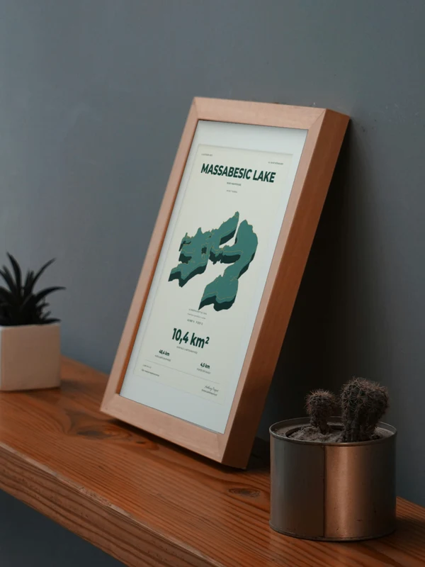 Œuvre Massabesic Lake intégrée numériquement dans un cadre, sur une tablette auprès de plantes. Encadrement et proportions indicatifs.
