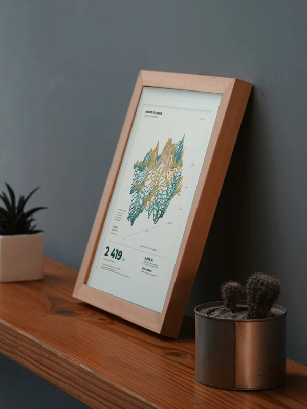 La obra Monte Olimpo integrada digitalmente en un marco, sobre una repisa junto a plantas. El marco y las proporciones son ilustrativos.
